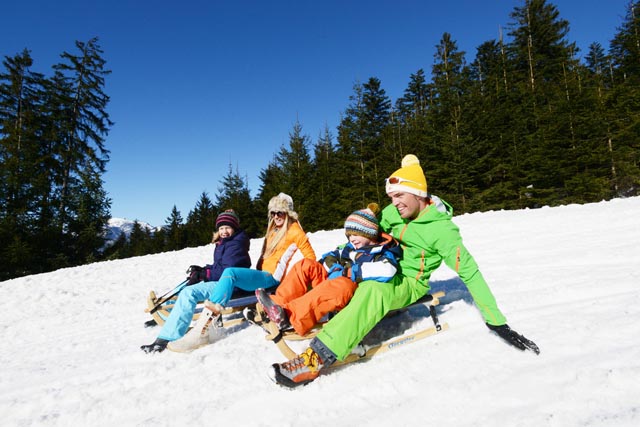 Familie auf der Rodelstrecke